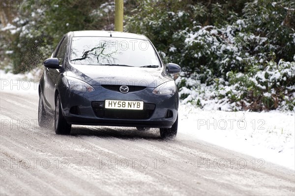 2009 Mazda 2 driving on snowy road Artist: Unknown.