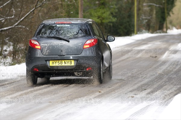 2009 Mazda 2 driving on snowy road Artist: Unknown.