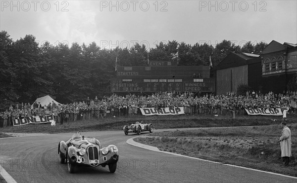 Alfa Romeo of Hugh Hunter leading a Riley at Crystal Palace, London, 1939. Artist: Bill Brunell.