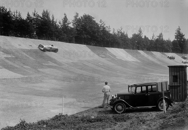 John Cobb's 24 litre Napier Railton on Byfleet Banking, BARC meeting, Brooklands, Surrey, 1933. Artist: Bill Brunell.