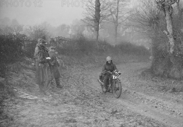 Woman riding a Royal Enfield motorcycle in the Gloucester Trial, c1930s. Artist: Bill Brunell.