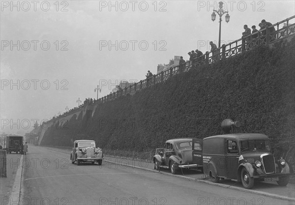 Daimler of CM Simpson and a Morris loudspeaker van on Madeira Drive, Brighton, RAC Rally, 1939. Artist: Bill Brunell.