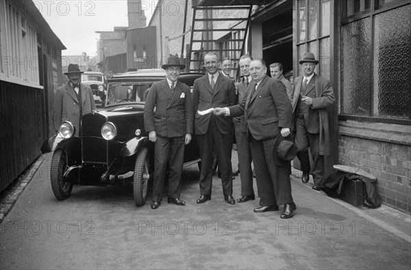 Group of men with a Triumph Super Seven, c1930(?). Artist: Bill Brunell.