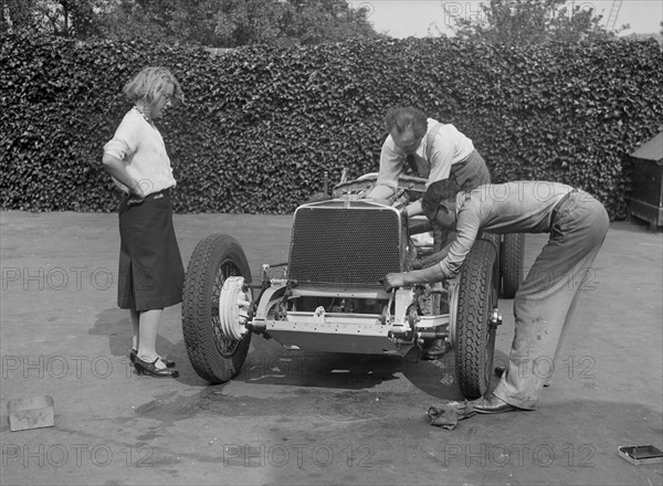 Working on the engine of Raymond Mays' Vauxhall-Villiers, c1930s. Artist: Bill Brunell.
