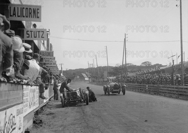 Bugatti Type 35 passing a Lombard in the pits at the Boulogne Motor Week, France, 1928. Artist: Bill Brunell.