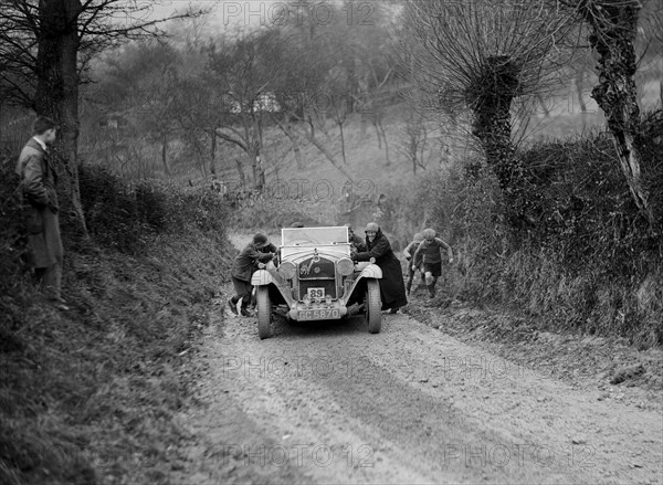 Alfa Romeo of KD Evans getting a push at the NWLMC London-Gloucester Trial, 1931. Artist: Bill Brunell.