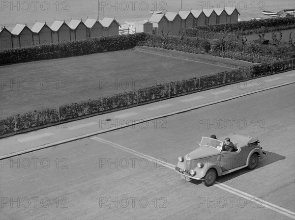 Ford Prefect tourer of JW Whalley competing in the RAC Rally, Madeira Drive, Brighton, 1939. Artist: Bill Brunell.