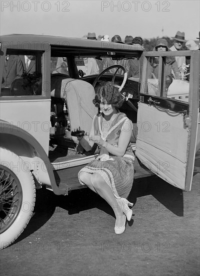 Paddy Naismith pouring a drink from the cocktail bar in her Ballot at the Southport Rally, 1928. Artist: Bill Brunell.