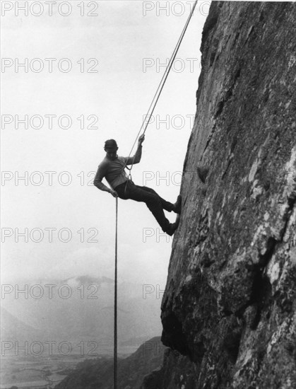 Boy abseiling down rock face, Outward Bound School, Eskdale, Cumbria, 1950. Artist: Unknown