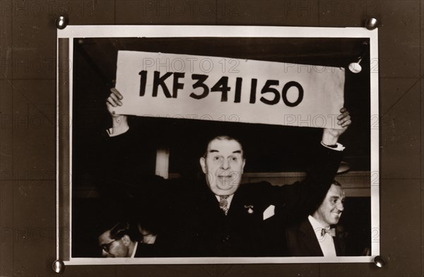 Lord Mackintosh holds up the first winning premium bond number, 1966. Artist: Unknown