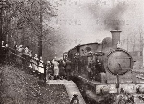 Passengers queuing for a steam rain at Rowntree's halt, York, Yorkshire, 1934. Artist: Unknown