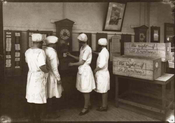 Girls use the clocking in machine, Rowntree factory, York, Yorkshire, 1929. Artist: Unknown