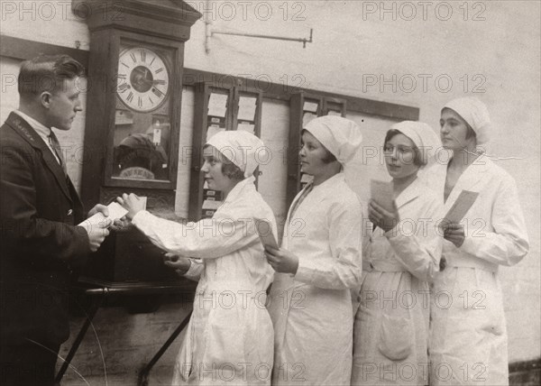 Girls queue at the Clocking-In machine, Rowntree factory, York, Yorkshire, 1933. Artist: Unknown