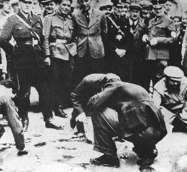 Jews are made to clean the streets of Vienna after the Anschluss, 1938. Artist: Unknown