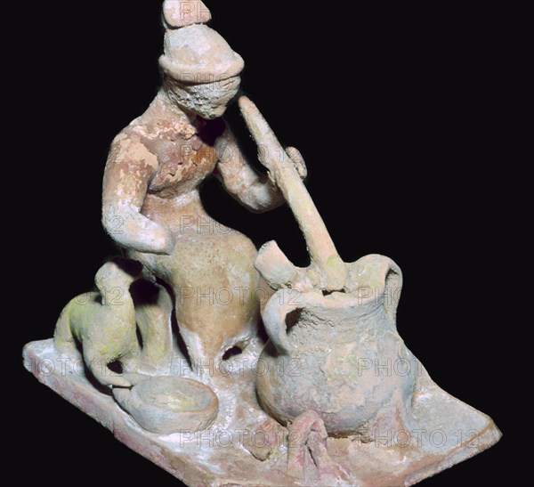Greek terracotta statuette of a woman cooking. Artist: Unknown