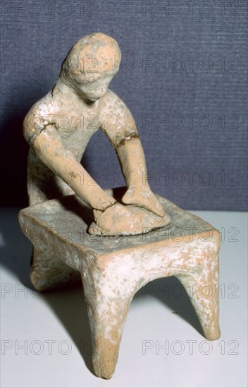 Greek terracotta of a woman making bread. Artist: Unknown
