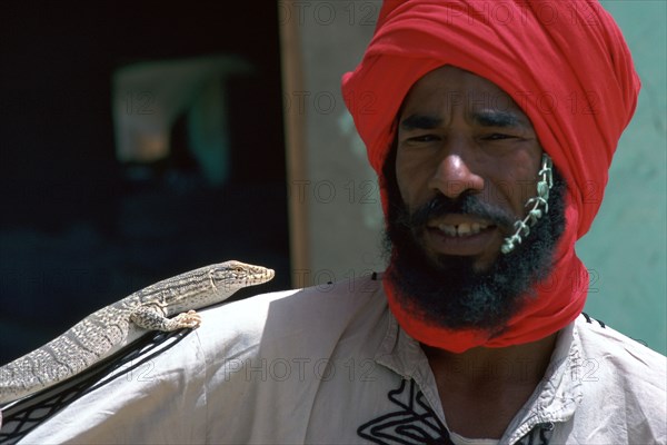 Keeper with a lizard in Tozeur zoo in Tunisia. Artist: Unknown