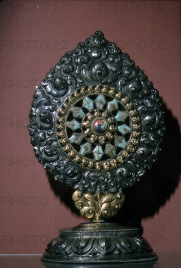 Tibetan Wheel of the Law inlaid with turquoise and coral. Artist: Unknown.