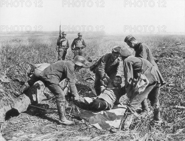 Wounded German soldier being moved by prisoners, Aisne, France, 18 July, 1918. Artist: Unknown