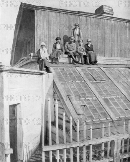 Tsar Nicholas II and his children sitting on a greenhouse, Tobolsk, Siberia, Russia, 1917. Artist: Unknown