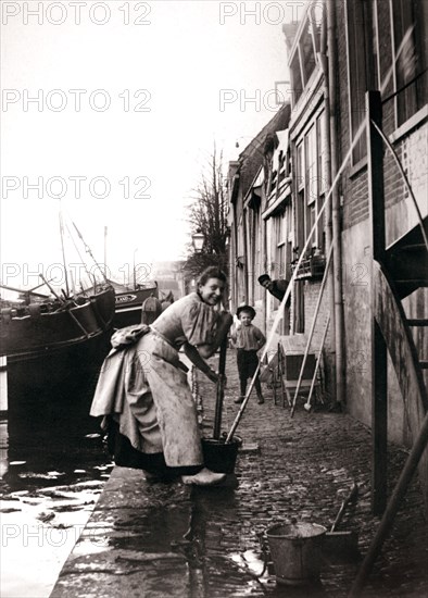 Woman mopping the street, Dordrecht, Netherlands, 1898.Artist: James Batkin