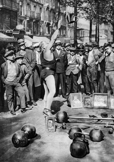 Strongman juggling with weights, Paris, 1931.Artist: Ernest Flammarion