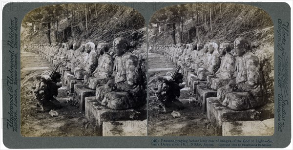 Peasant praying before a row of statues of the God of Light, Daiya river, Nikko, Japan, 1904.Artist: Underwood & Underwood