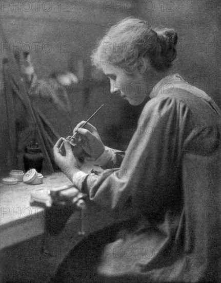 A craftswoman at work, 1911-1912.Artist: ET Holding