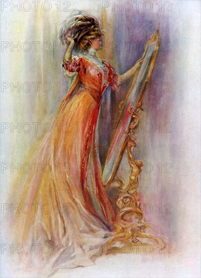 Woman admiring herself in a mirror, 1908-1909.Artist: Hubner & Wilson