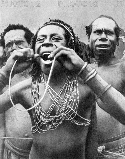 Swallowing canes in a ceremonial ritual, New Guinea, 1936.Artist: Wide World Photos