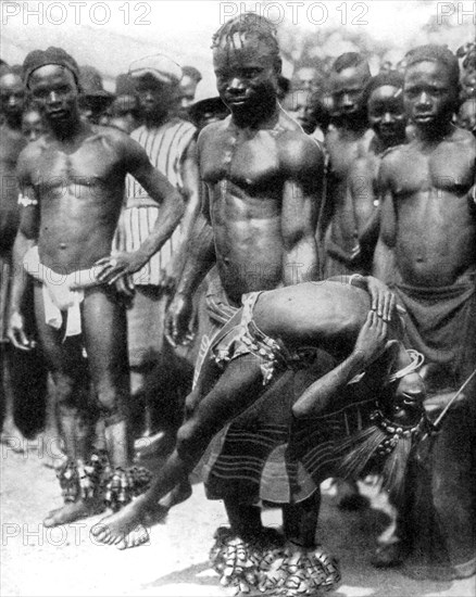 A Yafouba tribesman juggles with a girl, Ivory Coast, West Africa, 1936.Artist: Wide World Photos