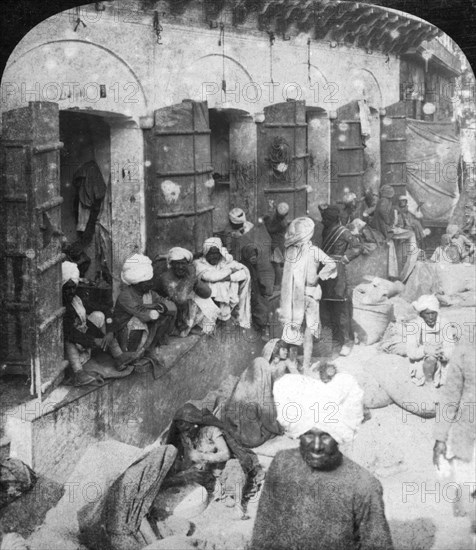 Indian women grinding corn between two round stones, Delhi, India, 1900s.Artist: Rose Stereographs