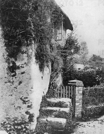 A cottage with an ancient 'upping stock', Cockington, Devon, 1924-1926.Artist: HJ Smith