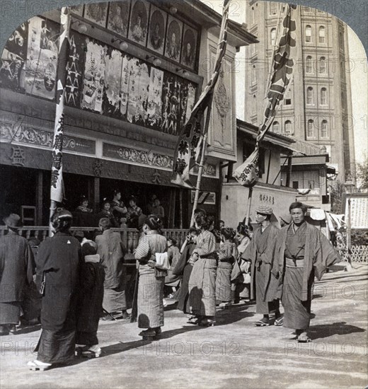 Watching a free show on Theatre Street, looking north to Asakusa Tower, Tokyo, Japan, 1904. Artist: Underwood & Underwood