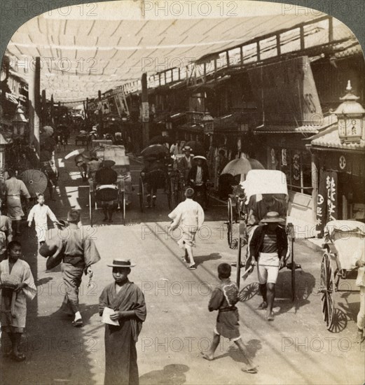 Midsummer traffic under the awnings of Shijo Bashidori, a busy thoroughfare of Kyoto, Japan, 1904. Artist: Underwood & Underwood