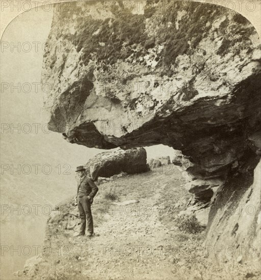 Man on a cliff overlooking Naeroyfjord, Sogne, Norway