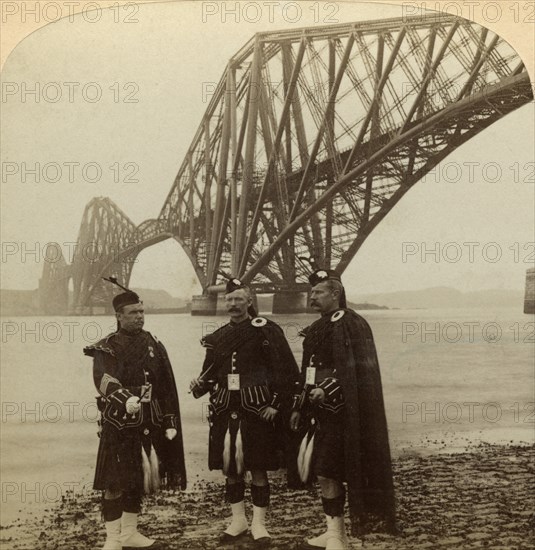 Men in Highland dress in front of the Forth Bridge, Scotland.Artist: Underwood & Underwood