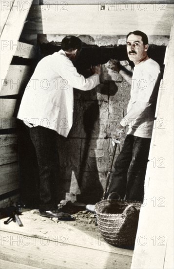 Howard Carter and a colleague excavating a tomb in the Valley of the Kings, Egypt, 1922. Artist: Harry Burton