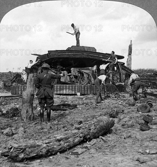 Engineers clearing a destroyed tank from a road, World War I, 1917-1918.Artist: Realistic Travels Publishers