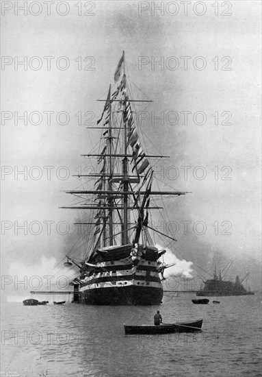 HMS 'Duke of Wellington' firing a Royal Salute as flagship at Portsmouth, Hampshire, 1896.Artist: Symonds & Co