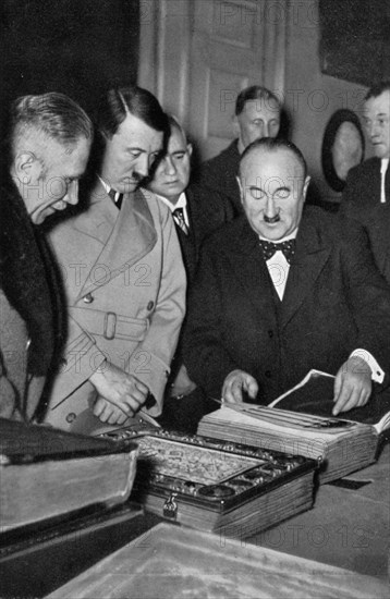 Adolf Hitler being shown the treasures of the Bavarian State Library, Germany, 1936. Artist: Unknown