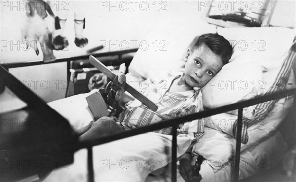 Greek boy from Pylos being nursed in the sick bay of the British battleship HMS 'Malaya', 1938. Artist: Unknown