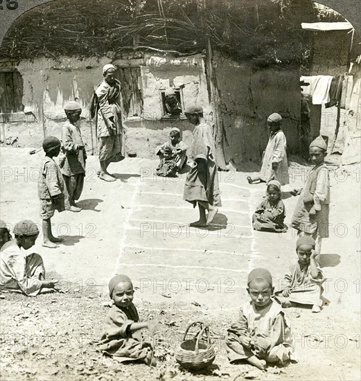 Children playing hopscotch, Kashmir, India, c1900s(?).Artist: Underwood & Underwood