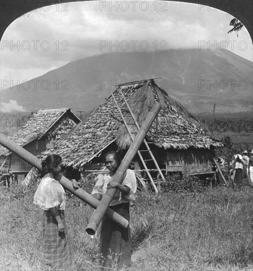 Native girls with their water vessels made from shafts of bamboo, Philippines, 1907. Artist: HC White