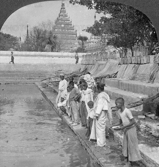 Pilgrims feeding holy turtles, Arakan Pagoda, Mandalay, Burma, 1908.  Artist: Stereo Travel Co