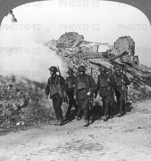 Troops passing the ruins of Monchy on the way up the line, France, World War I, c1914-c1918. Artist: Realistic Travels Publishers