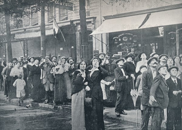 Paris crowd watching one of the German aeroplanes flying over the city, c1914. Artist: Unknown