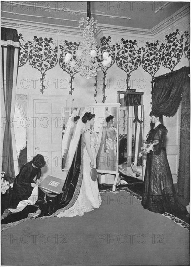 The finishing touches of a dressmaker, London, c1901 (1901). Artist: Unknown.