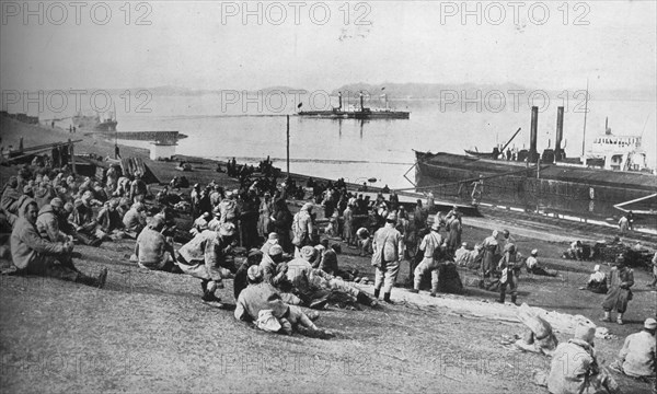 ''Austrian prisoners taken by Serbians resting at mid-day on the banks of the Danube', 1915. Artist: Unknown.