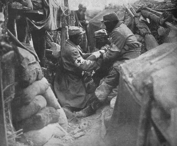 'First aid to a wounded man in one of the French trenches', 1915. Artist: Unknown.
